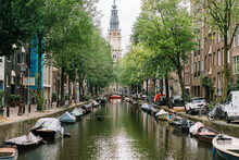 Scenic Cityscape With Old Protestant Church And Boats On Canal