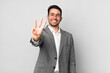© kues1 - young adult hispanic man smiling and looking friendly, showing number three. business concept