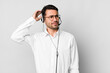 young adult hispanic man smiling happily and daydreaming or doubting. telemarketer concept