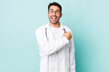 young adult hispanic man feeling happy and facing a challenge or celebrating. physician concept