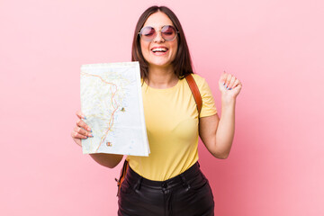 young pretty woman shouting aggressively with an angry expression. tourist with a map concept