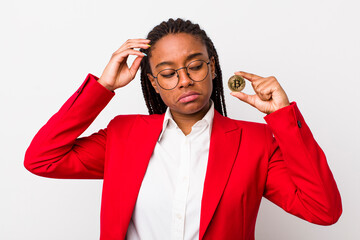 Wall Mural - young adult black woman feeling puzzled and confused, scratching head. crypto coin concept