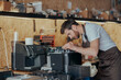 Man worker repair a coffee machine in own workshop