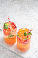 Wall Mural - Orange cocktail with strawberries, summer drink