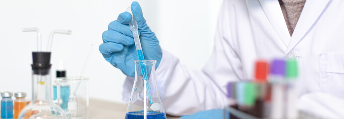 Scientists are carrying blue chemical test tubes to prepare for the determination of chemical composition and biological mass in a scientific laboratory, Scientists and research in the lab Concept.