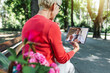 © Mediteraneo - Telemedicine concept, old woman with tablet pc during an online consultation with her doctor in the park