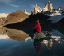 A Hiker Sits On A Rock In Laguna De Los Tres In Front Of The Ico