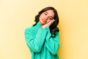 Young hispanic woman isolated on yellow background yawning showing a tired gesture covering mouth with hand.