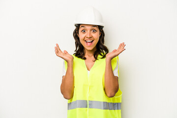 Wall Mural - Young laborer hispanic woman isolated on white background surprised and shocked.