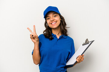 Wall Mural - Young hispanic woman delivery man isolated on white background joyful and carefree showing a peace symbol with fingers.