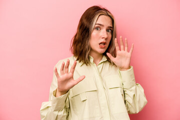 Wall Mural - Young caucasian woman isolated on pink background being shocked due to an imminent danger