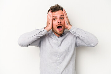 Wall Mural - Young caucasian man isolated on white background being shocked, she has remembered important meeting.