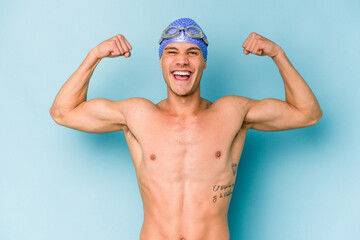 Young caucasian swimmer man isolated on blue background
