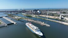 4k Aerial Video Of Cruise Ship Leaving Large Sea Sluice Towards Amsterdam In The Netherlands. Tata Steel Factory In The Back Ground