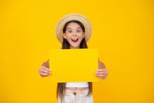 Surprised Teen Girl Hold Empty Advertisement Paper With Copy Space On Yellow Background