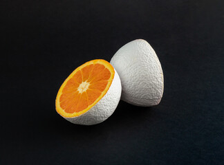 Wall Mural - White colored orange fruit on black background. Minimal food  concept. Abstract idea.