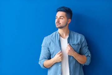 Wall Mural - Stylish young man with unusual blue hair and beard on color background