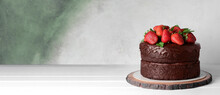 Tasty Chocolate Cake With Strawberry On Table Against Grunge Background With Space For Text