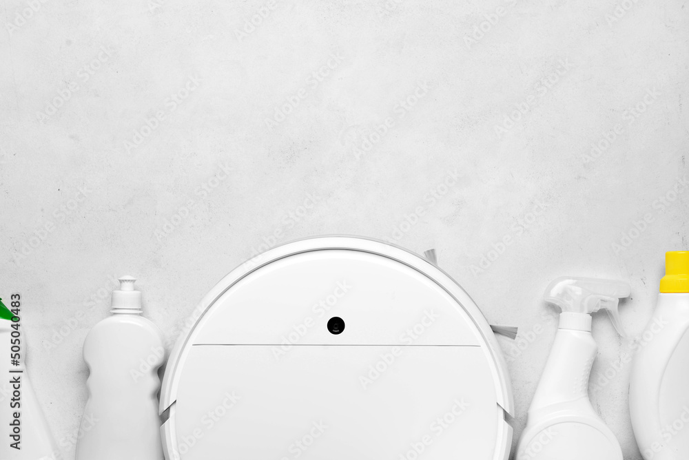 Robot vacuum cleaner and bottles of detergent on light background, closeup
