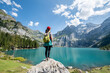 canvas print picture - Young woman hiking near Oeschinensee (Oeschinen Lake) in summer, Kandersteg, Switzerland