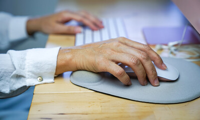 woman's fingers clicking on mouse, resting her wrist on wrist rest. ergonomic concept,. close up vie