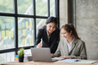 © PaeGAG - Two young asian business woman working together in office space, brainstorm sharing ideas concept.
