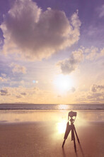 Photographer And Camera On Stand And Beach At Sunset And Love Heart Cloud