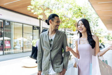 Wall Mural - Asian young man and woman shopping goods outdoors in department store. 