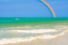 インド洋のサンゴ礁の海にかかる虹