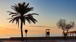 Silhouetten einer Palme, eines Strassenschilds und eines Rettungsschwimmerhäuschens im Morgenlicht, an der Promenade von Cala Millor, Mallorca