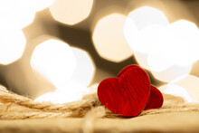 Valentine's Day Greetings Concept. Little Red Wooden Heart Close Up, Party Lights Bokeh On Background. Valentines Greeting Card.