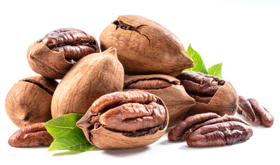 Wall Mural - Shelled and cracked pecan nuts with leaves close-up on white background.