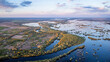 Picturesque aerial landscape of village near flooded valley of river Desna at sunset. Countryside in Ukraine, last sun rays illuminating small village on bank of river during powerful flood
