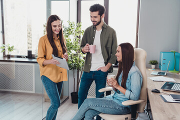 Wall Mural - Portrait of three attractive experienced skilled cheerful people hr experts drinking discussing finance at work place station indoors