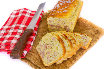 savory cake with cut ham on a white background