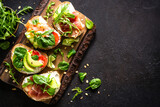 Fototapeta Kawa jest smaczna - Open sandwich set with cream cheese, prosciutto, salmon, avocado and fresh greens.