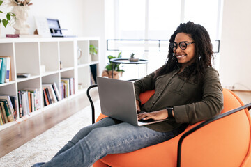 Canvas Print - Portrait of smiling black woman using laptop at home