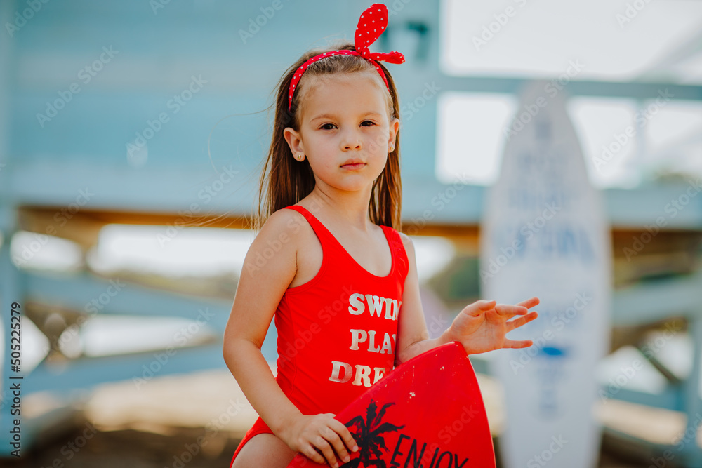pretty-little-girl-in-red-bikini-posing-with-small-surfboard-like-a