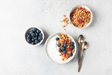 Wall Mural - Greek yogurt bowl with granola and berries on grey concrete table background, top view, copy space for text or design elements