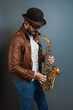 © RomanWhale studio - saxophonist male musician in a hat playing, saxophone player