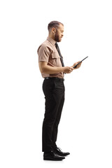 Wall Mural - Full length profile shot of a male security officer looking at a clipboard