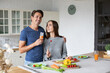 © BestForYou - Romantic young couple cooking together in the kitchen having a great time together.