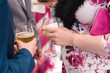 Detalle de una mujer y un hombre sosteniendo dos copas con bebida durante la celebración de un evento. Concepto de beber alcohol durante el embarazo.