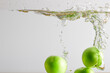  green plum dropping into water and splash of water