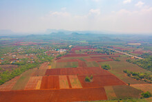 Aerial Top View Of Red Soil, Crops Field With Green Mountain Hill In Agriculture Concept. Nature Landscape Background In Thailand. Harvest
