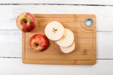 Wall Mural - Fresh red apples sliced on a bamboo cutting board