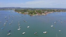 Bosham Village On An Inland Estuary With Boats And Yachts Anchored In This Beautiful Location In West Sussex, Aerial Footage.