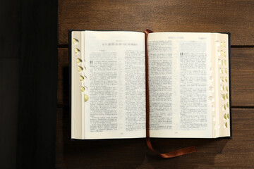 Open Bible on wooden table, top view. Christian religious book