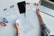 © AnnaStills - Top-down view shot of unrecognizable woman working in US embassy working with travel visa applications