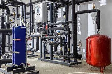 Industrial basement with heating pipes, pressure gauges, valves and heat exchangers